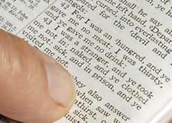 Pointing to Matthew 25:42-43 in a Bible.