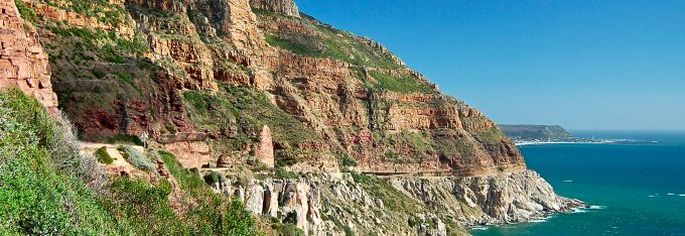 Chapman’s Peak Drive south of Cape Town, South Africa. The ‘Chappies’ runs on top of a grey granite pluton which drops steeply into the sea. Brown sedimentary strata deposited as the floodwaters rose sit alongside and above the road