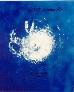 tiny impact crater in space shuttle window